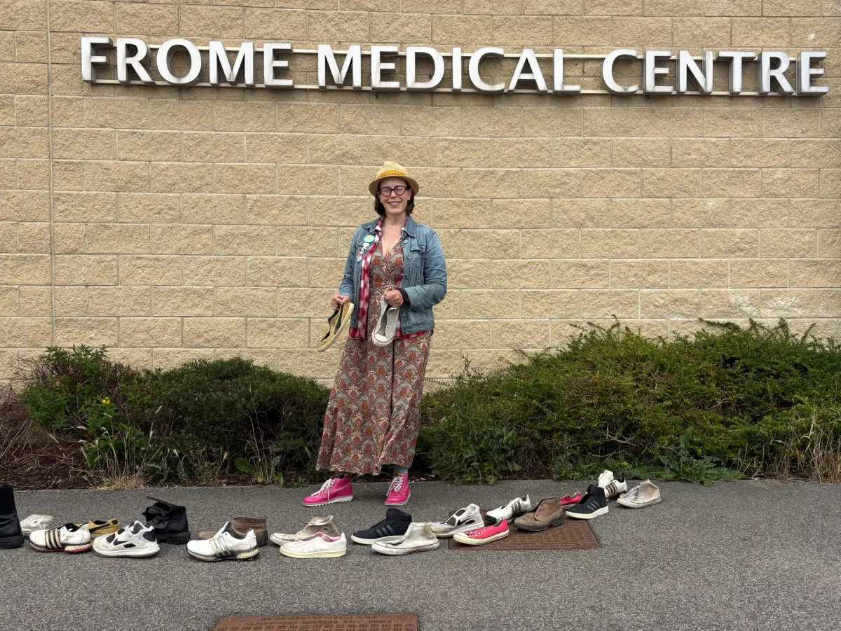 woman outside Frome Medical Centre holding shoes
